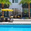 a pool with chairs and umbrellas by a building